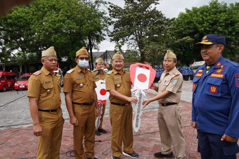 Bupati Garut, Rudy Gunawan, menyerahkan secara simbolis bantuan hibah 7 unit mobil dari Pemerintah Jepang kepada Kepala Disdamkar Garut, Eded Komara dan Kepala Dinkes Garut, dr. Maskut Farid, di Lapang Setda Garut, Kecamatan Tarogong Kidul, Kabupaten Garut, Senin (27/2/2023). (Foto : Deni Seftiana & M. Azi Zulhakim/Diskominfo Garut).