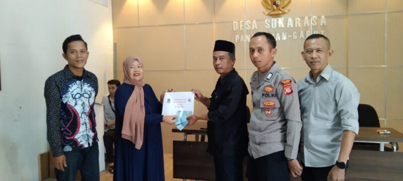 Kepala Desa Sukarasa Haris menyerahkan BLT DD Secara simbolis kepada salah seorang warganya ( Poto ) ihsan