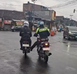 Seorang pengendara motor yang mengalami mogok mendapatkan bantuan dari petugas polisi yang sedang jaga di Jalan Sukadana, Minggu (06/04/2025).